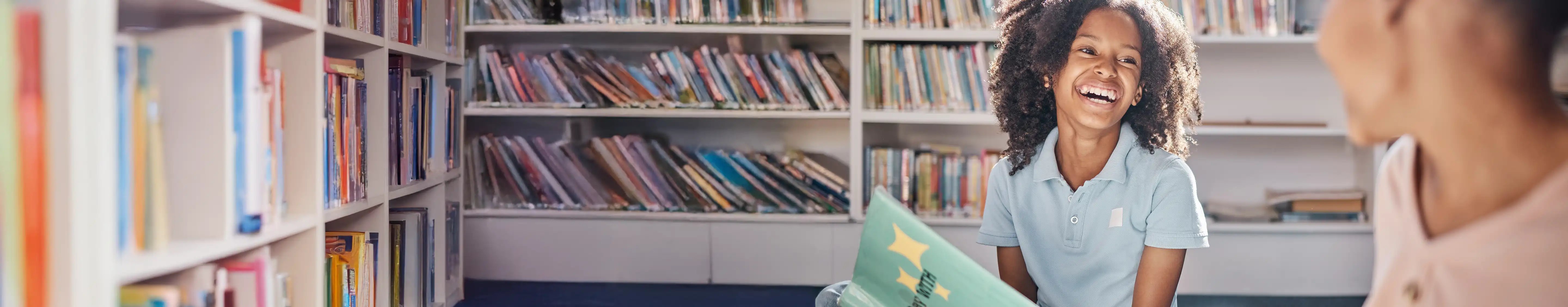Child holding a book and smiling