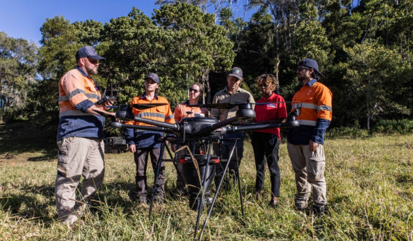 Group of people standing around a drone